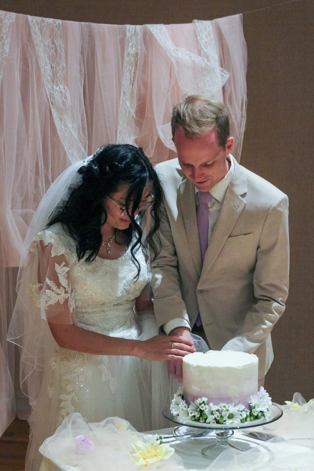 Couple sharing a moment by the wedding cake